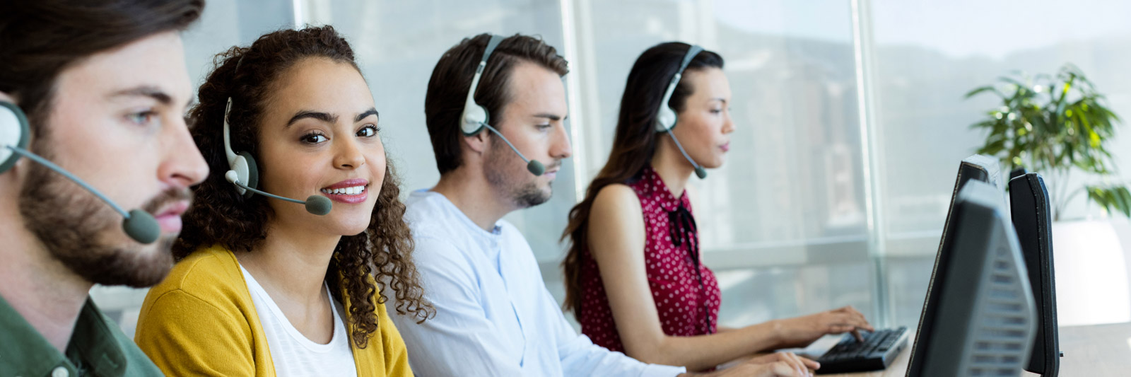 a group of young customer service representatives with headsets