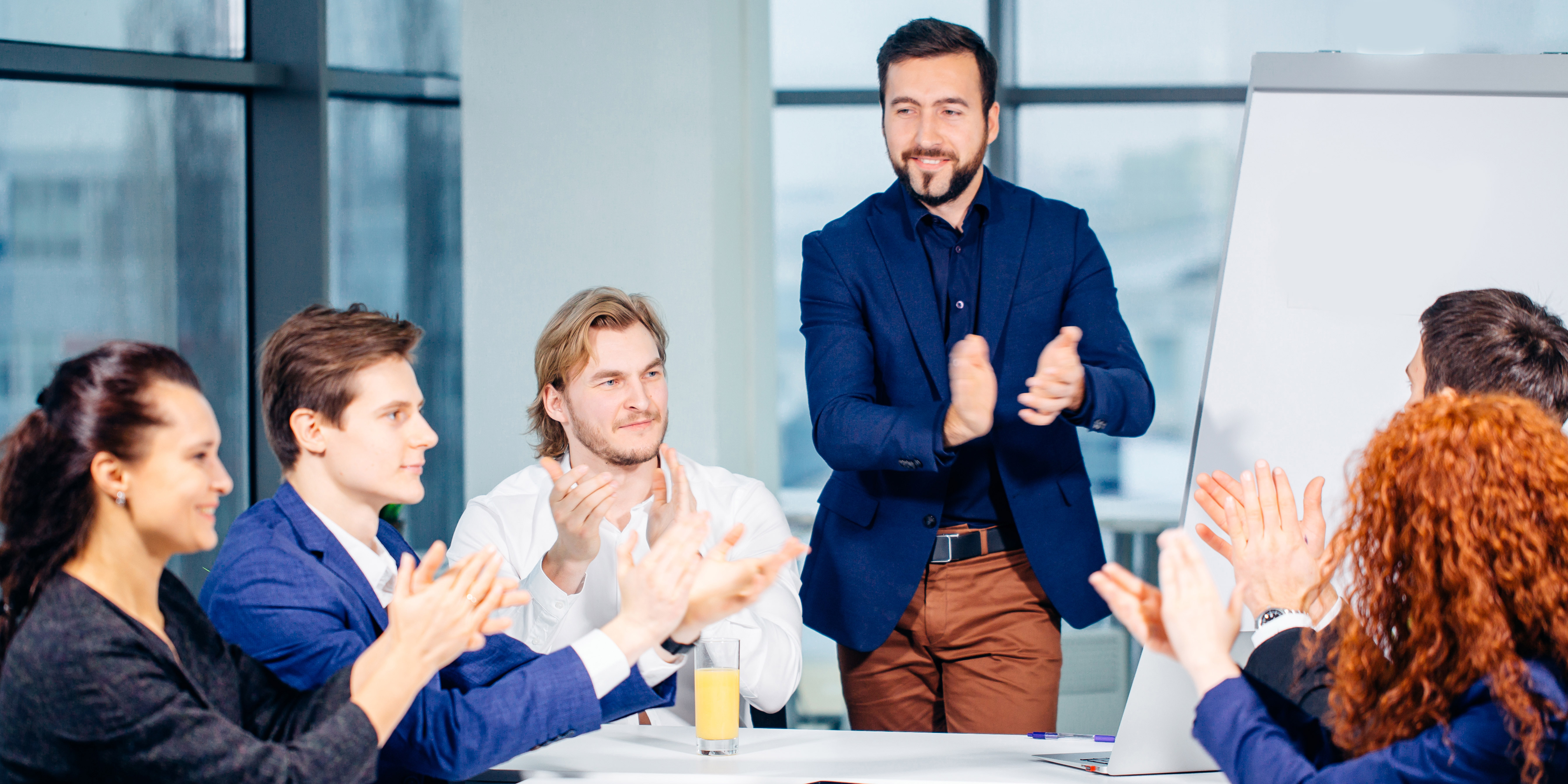 Manager and team clapping at table