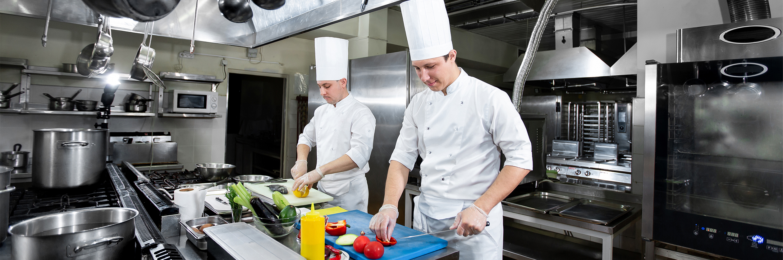 two chefs preparing vegetables in a commercial kitchen