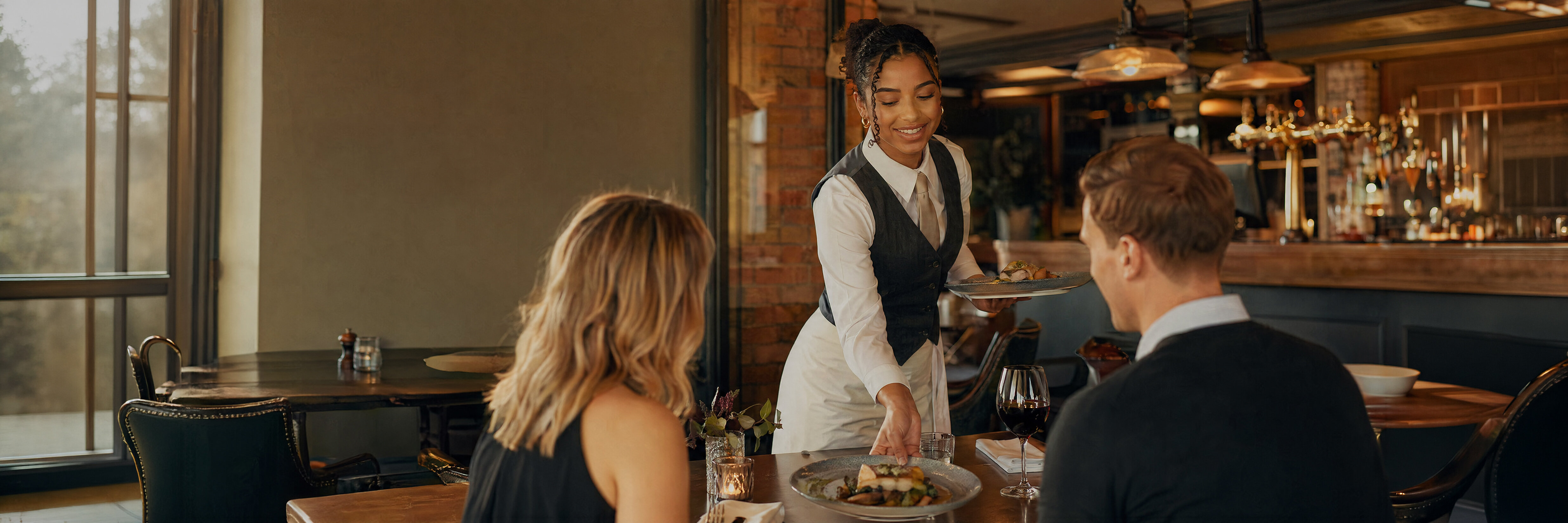 A food and beverage team member serving customers in a hospitality setting