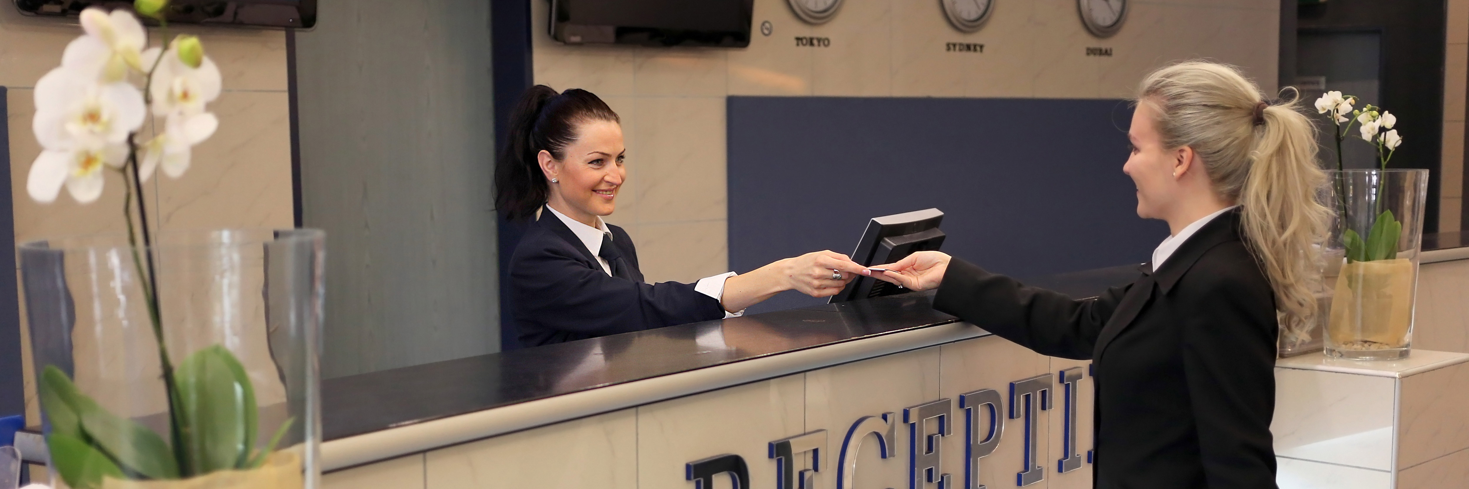a customer recieving her keycard from hotel reception