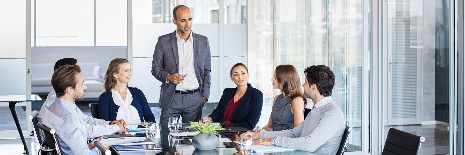 a team leader stood at a table talking to his team