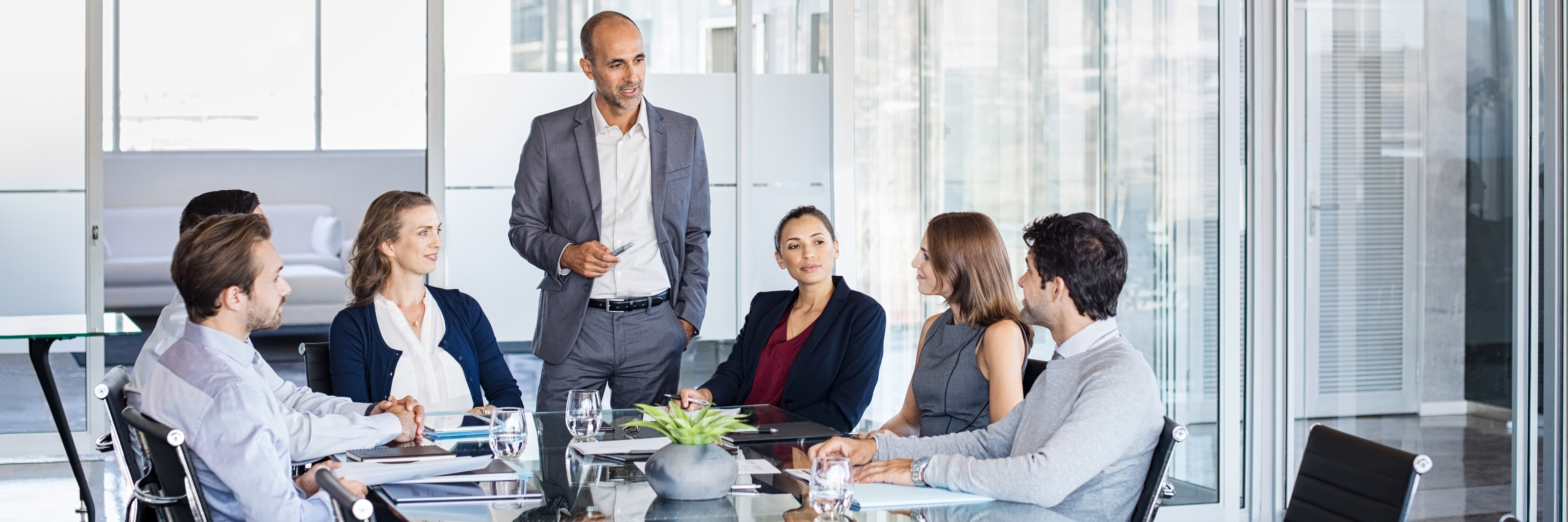 a team leader stood at a table talking to his team