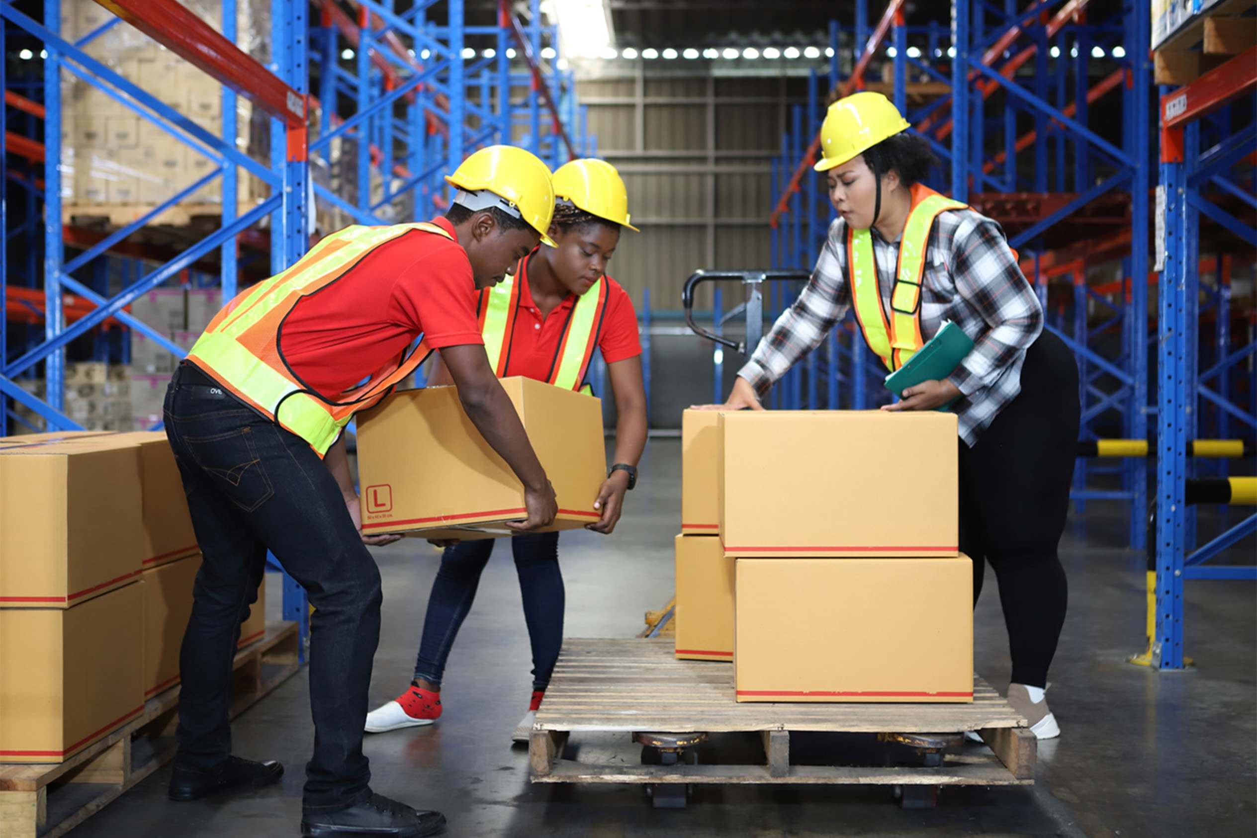 Two apprentices helping move boxes in a warehouse